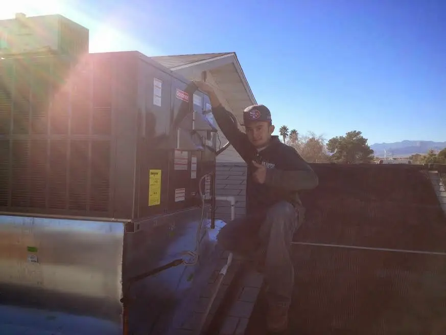 HVAC technician performing Heat Pump Repair on a rooftop unit in Beebe